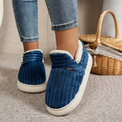 Blue WarmStep winter slippers worn indoors with jeans