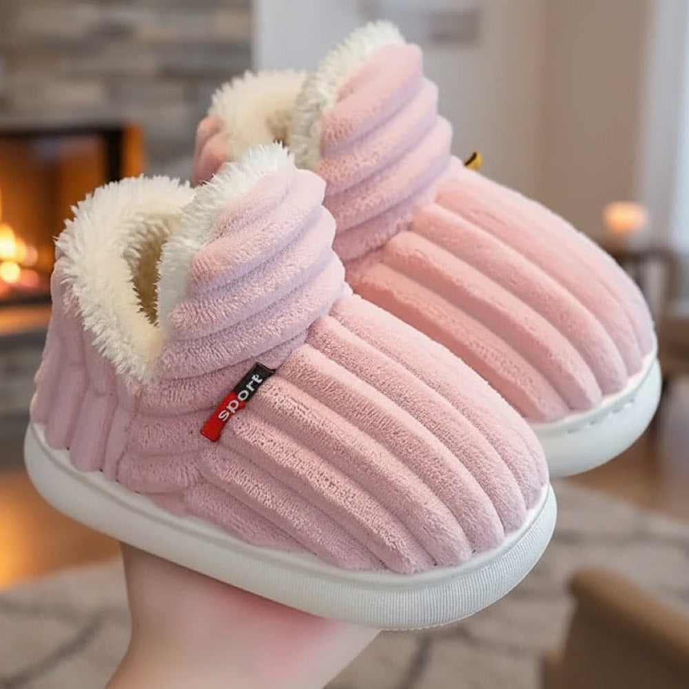 Pink WarmStep winter slippers in front of a fireplace